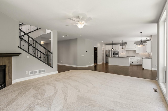 1206 Rosemary Ln, Chaska, MN 55318 - living area with dark colored carpet, ceiling fan, baseboards, recessed lighting, and a tile fireplace
