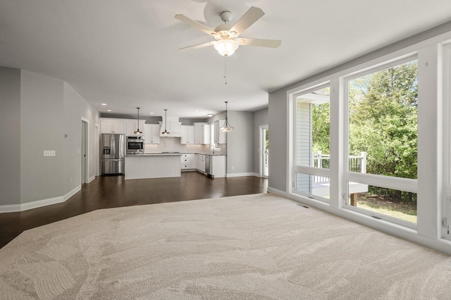 1206 Rosemary Ln, Chaska, MN 55318 - unfurnished living room featuring baseboards, healthy amount of natural light, ceiling fan, and dark wood-style floors