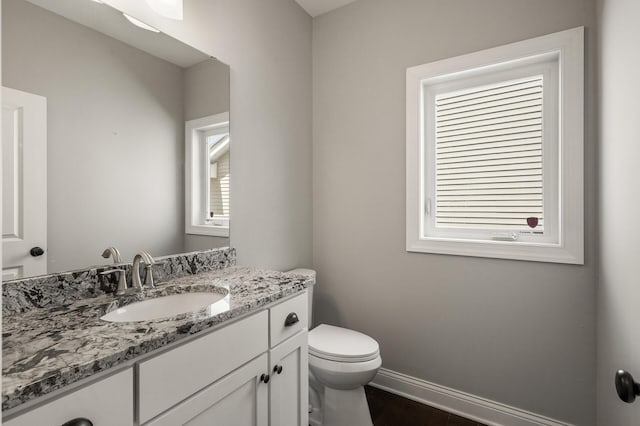 1206 Rosemary Ln, Chaska, MN 55318 - bathroom with toilet, vanity, wood finished floors, and baseboards