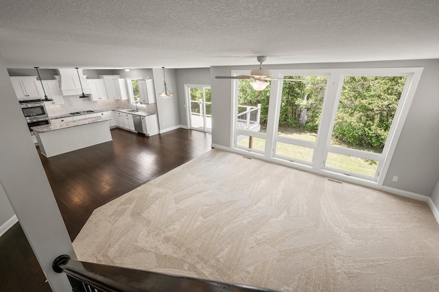 1206 Rosemary Ln, Chaska, MN 55318 - unfurnished living room featuring a ceiling fan, baseboards, a sink, a textured ceiling, and dark wood-style flooring