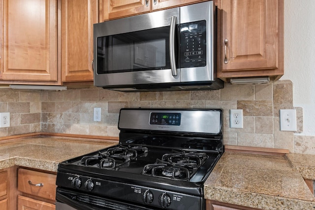 1930 Aldrich Ave S Unit C001, Minneapolis, MN 55403 - kitchen with gas range, stainless steel microwave, tile counters, and decorative backsplash