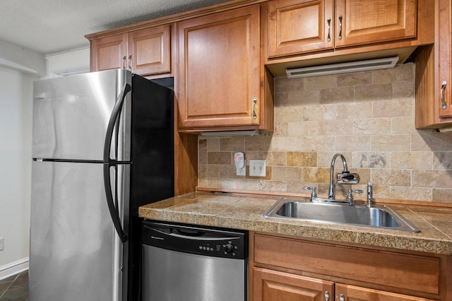 1930 Aldrich Ave S Unit C001, Minneapolis, MN 55403 - kitchen featuring appliances with stainless steel finishes, a sink, tile countertops, tasteful backsplash, and brown cabinetry