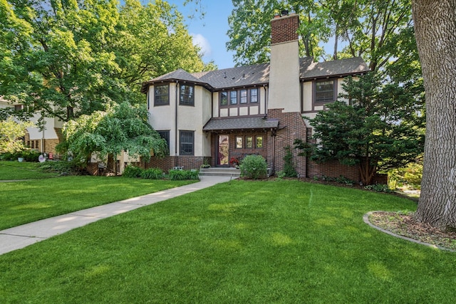 5319 Upton Ave S, Minneapolis, MN 55410 - tudor home featuring a front yard, stucco siding, a chimney, and brick siding