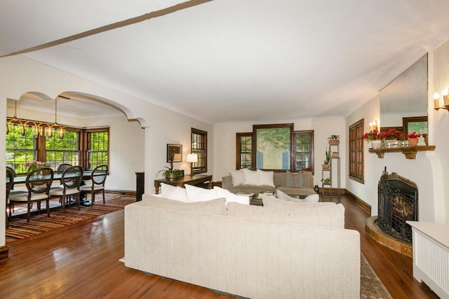 5319 Upton Ave S, Minneapolis, MN 55410 - living room with arched walkways, dark wood-type flooring, and a fireplace with raised hearth