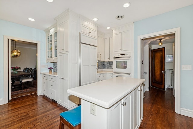 5319 Upton Ave S, Minneapolis, MN 55410 - kitchen featuring dark wood-style flooring, white cabinets, light countertops, tasteful backsplash, and recessed lighting