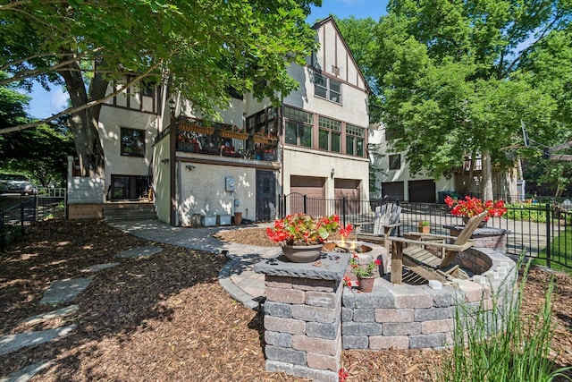 5319 Upton Ave S, Minneapolis, MN 55410 - rear view of house with stucco siding, an attached garage, and a balcony