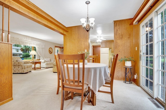 2168 Southwood Dr, White Bear Lake, MN 55110 - dining space with carpet, wood walls, plenty of natural light, a chandelier, and ceiling fan