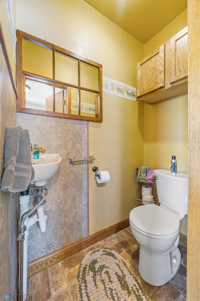 114 2nd Ave E, West Fargo, ND 58078 - bathroom with toilet, stone finish floors, baseboards, and a sink