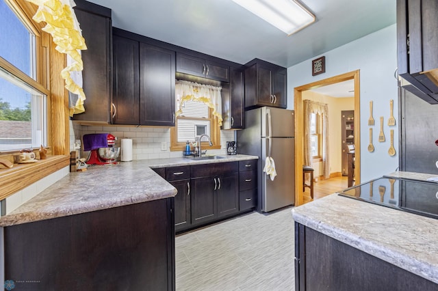114 2nd Ave E, West Fargo, ND 58078 - kitchen with freestanding refrigerator, a sink, tasteful backsplash, and light countertops