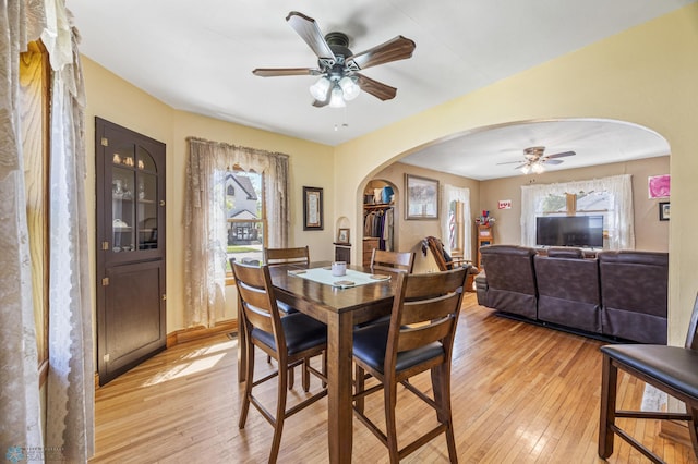 114 2nd Ave E, West Fargo, ND 58078 - dining area featuring arched walkways, ceiling fan, light wood-style floors, and healthy amount of natural light