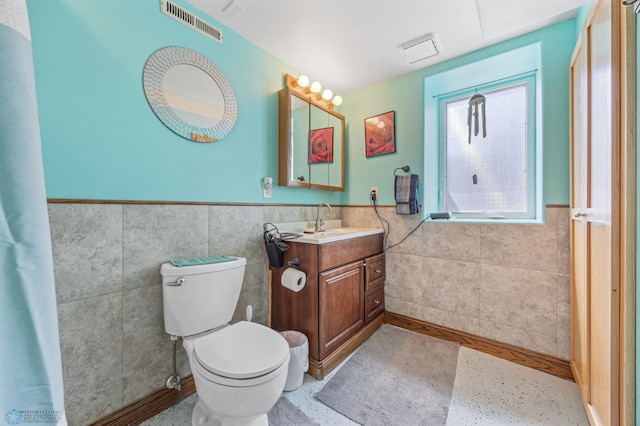 114 2nd Ave E, West Fargo, ND 58078 - bathroom with tile walls, wainscoting, vanity, and toilet