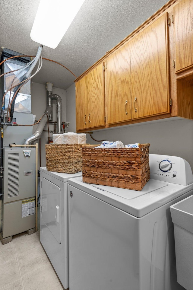 1022 17th Ave SE, Forest Lake, MN 55025 - laundry area featuring cabinet space, washer and dryer, a textured ceiling, heating unit, and light tile patterned flooring