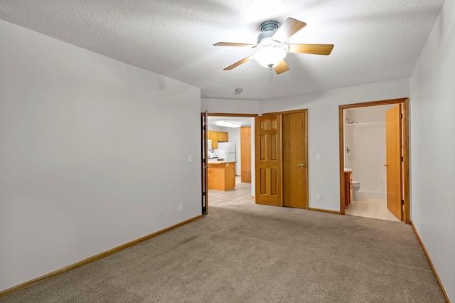1022 17th Ave SE, Forest Lake, MN 55025 - unfurnished bedroom with light colored carpet, connected bathroom, baseboards, and a textured ceiling