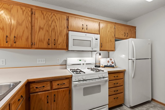 1022 17th Ave SE, Forest Lake, MN 55025 - kitchen with white appliances, light countertops, brown cabinets, and a textured ceiling