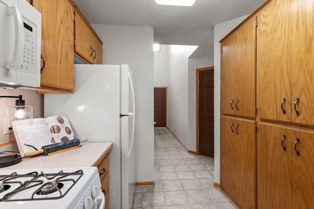 1022 17th Ave SE, Forest Lake, MN 55025 - kitchen with white appliances, light countertops, brown cabinets, baseboards, and light tile patterned flooring