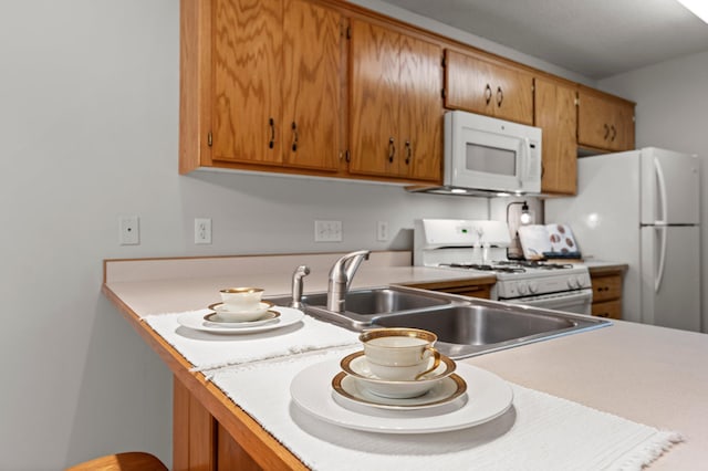 1022 17th Ave SE, Forest Lake, MN 55025 - kitchen with white appliances, light countertops, brown cabinetry, and a sink