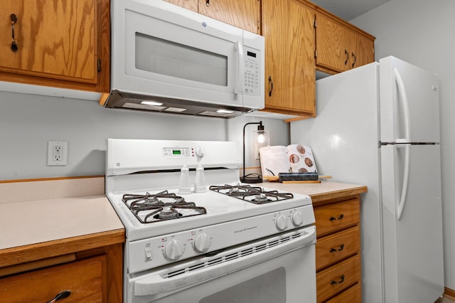 1022 17th Ave SE, Forest Lake, MN 55025 - kitchen with white appliances, light countertops, and brown cabinets