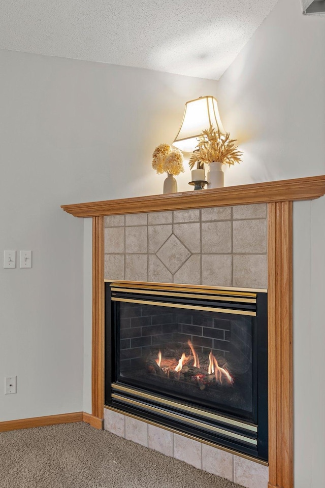 1022 17th Ave SE, Forest Lake, MN 55025 - detailed view of a lit fireplace, carpet flooring, a textured ceiling, and baseboards