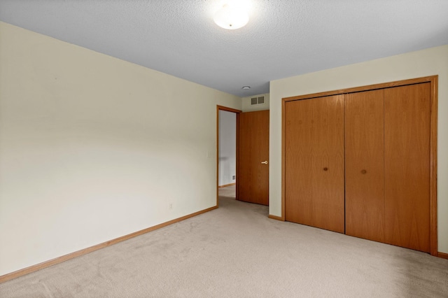 1022 17th Ave SE, Forest Lake, MN 55025 - unfurnished bedroom with light colored carpet, a closet, baseboards, and a textured ceiling