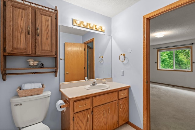 1022 17th Ave SE, Forest Lake, MN 55025 - bathroom featuring a textured ceiling, vanity, toilet, and baseboards