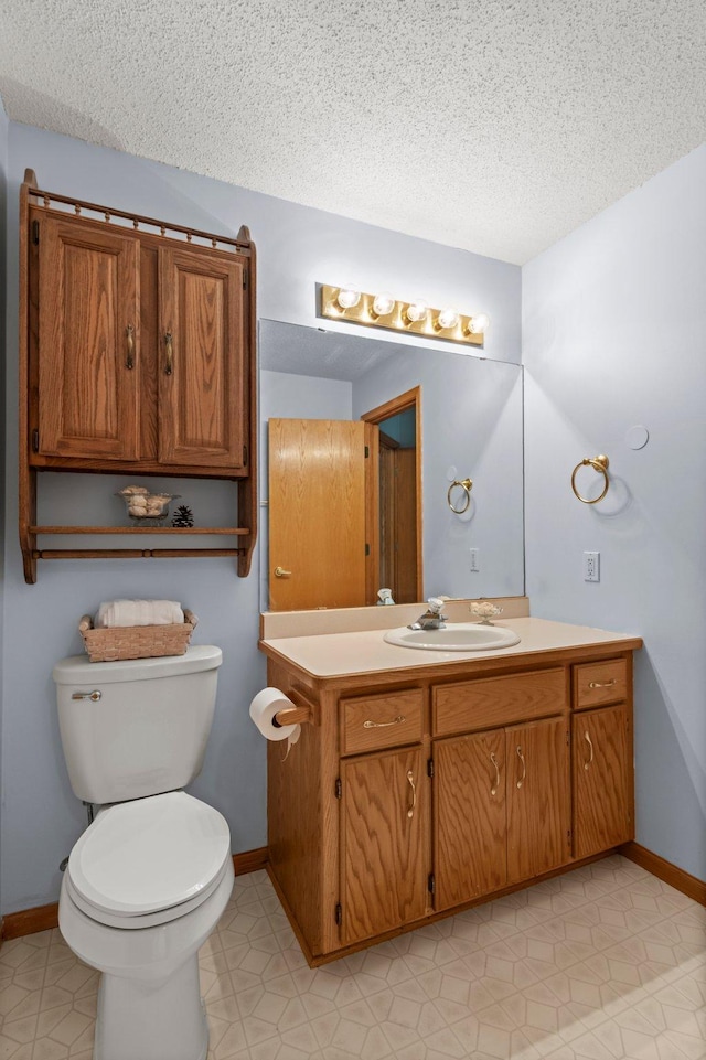 1022 17th Ave SE, Forest Lake, MN 55025 - bathroom featuring toilet, vanity, a textured ceiling, and baseboards