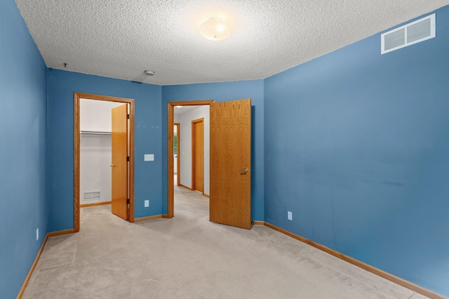 1022 17th Ave SE, Forest Lake, MN 55025 - unfurnished bedroom with baseboards, a textured ceiling, a spacious closet, carpet floors, and a closet
