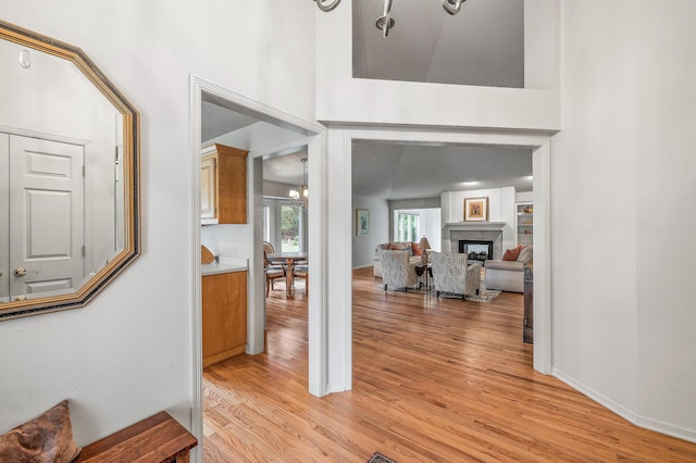 2600 Parkview Ct, White Bear Twp, MN 55110 - entrance foyer with light wood finished floors, a chandelier, a fireplace, and a towering ceiling