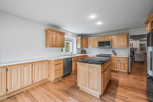 2600 Parkview Ct, White Bear Twp, MN 55110 - kitchen with stainless steel appliances, a textured ceiling, a center island, light wood-style floors, and a sink