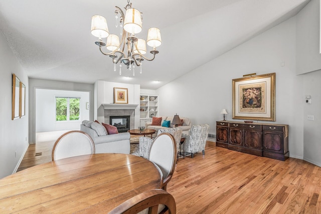 2600 Parkview Ct, White Bear Twp, MN 55110 - dining space with light wood-style floors, lofted ceiling, a chandelier, a fireplace, and baseboards