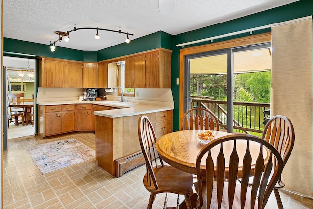 6504 Warren Ave S, Edina, MN 55439 - kitchen with brick patterned floors, light countertops, a peninsula, a sink, and brown cabinetry
