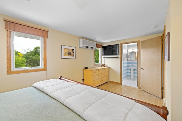 6504 Warren Ave S, Edina, MN 55439 - bedroom with a wall mounted air conditioner, light wood-style floors, ensuite bathroom, and baseboards