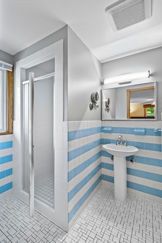 6504 Warren Ave S, Edina, MN 55439 - full bathroom featuring tile walls, a stall shower, tile patterned flooring, and wainscoting