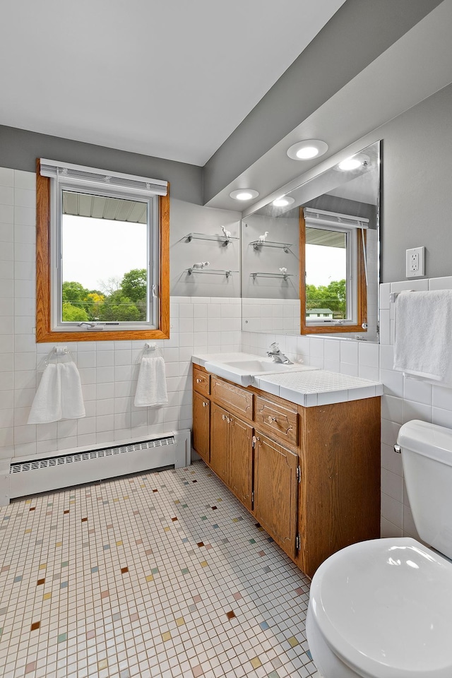 6504 Warren Ave S, Edina, MN 55439 - bathroom with tile walls, vanity, a baseboard heating unit, toilet, and tile patterned floors