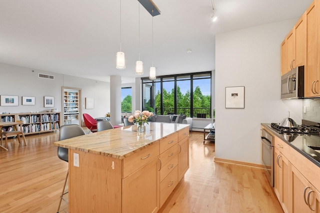 215 10th Ave S Unit 312, Minneapolis, MN 55415 - kitchen featuring appliances with stainless steel finishes, open floor plan, and light brown cabinetry