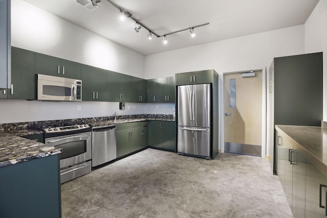 215 10th Ave S Unit 312, Minneapolis, MN 55415 - kitchen featuring appliances with stainless steel finishes, concrete floors, track lighting, and dark stone countertops