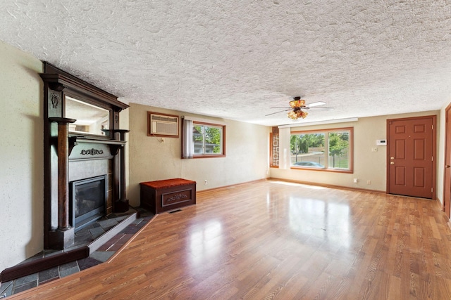 39 Magnolia Ave E, Saint Paul, MN 55117 - unfurnished living room with a tiled fireplace, a textured ceiling, wood finished floors, a ceiling fan, and healthy amount of natural light