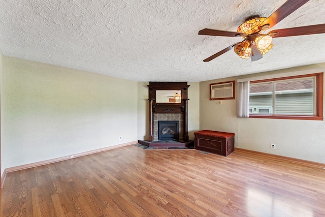 39 Magnolia Ave E, Saint Paul, MN 55117 - unfurnished living room featuring a tile fireplace, a textured ceiling, wood finished floors, ceiling fan, and baseboards
