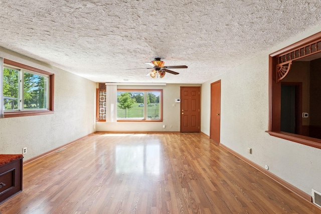39 Magnolia Ave E, Saint Paul, MN 55117 - unfurnished living room featuring wood finished floors, a ceiling fan, baseboards, a textured ceiling, and a textured wall