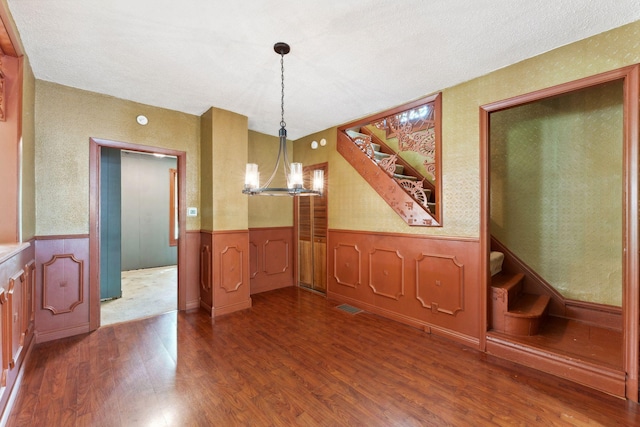 39 Magnolia Ave E, Saint Paul, MN 55117 - unfurnished dining area with a chandelier, dark wood-style floors, wainscoting, and stairs