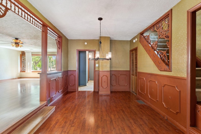 39 Magnolia Ave E, Saint Paul, MN 55117 - unfurnished dining area with a chandelier, a wainscoted wall, dark wood-style floors, a textured ceiling, and ceiling fan