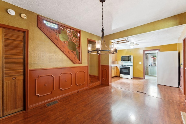 39 Magnolia Ave E, Saint Paul, MN 55117 - unfurnished dining area featuring a chandelier, wood finished floors, a wainscoted wall, and a textured ceiling