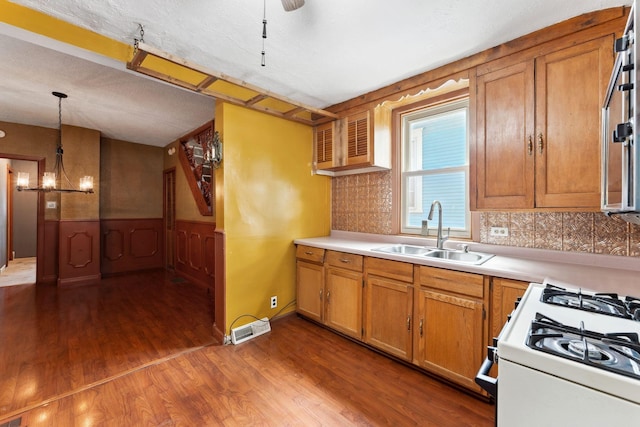 39 Magnolia Ave E, Saint Paul, MN 55117 - kitchen with a sink, dark wood-type flooring, light countertops, brown cabinets, and wainscoting