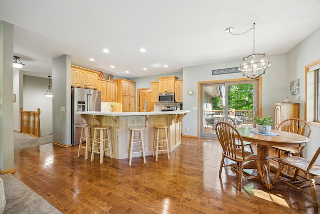 14450 Blackberry Ct, Baxter, MN 56425 - kitchen with stainless steel appliances, light wood-style flooring, light countertops, a kitchen bar, and recessed lighting