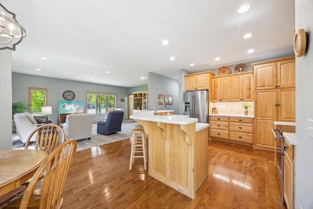 14450 Blackberry Ct, Baxter, MN 56425 - kitchen with stainless steel fridge, open floor plan, light countertops, a kitchen island with sink, and a kitchen breakfast bar
