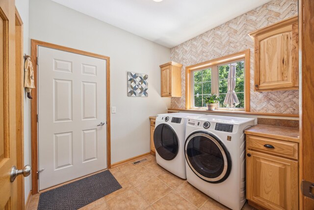 14450 Blackberry Ct, Baxter, MN 56425 - laundry area featuring independent washer and dryer, cabinet space, light tile patterned floors, and baseboards