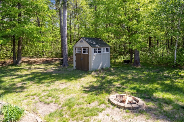 14450 Blackberry Ct, Baxter, MN 56425 - view of green lawn featuring an outdoor fire pit and a wooded view