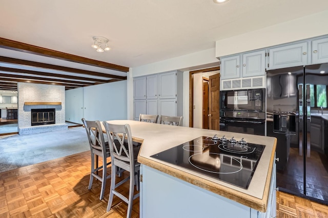 1321 Dallager Ct, Stillwater, MN 55082 - kitchen with black appliances, a fireplace, beam ceiling, open floor plan, and light countertops