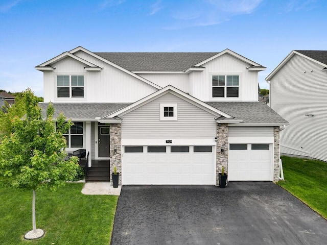 7121 208th St N, Forest Lake, MN 55025 - view of front of home featuring a shingled roof, asphalt driveway, a garage, and a front yard