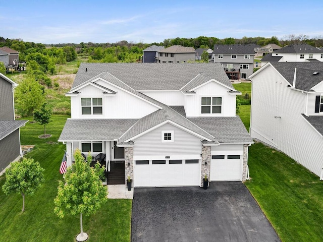 7121 208th St N, Forest Lake, MN 55025 - traditional-style house with driveway, an attached garage, a shingled roof, and stone siding
