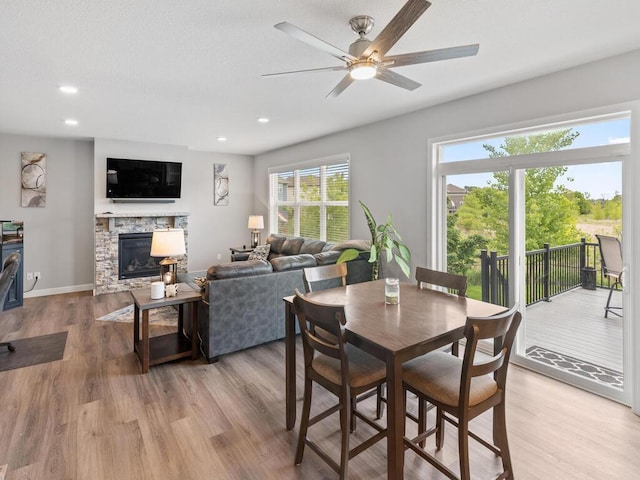 7121 208th St N, Forest Lake, MN 55025 - dining area featuring light wood-style floors, a ceiling fan, recessed lighting, and a fireplace